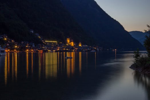 Peaceful evening view of illuminated Hallstatt reflecting on the lake.